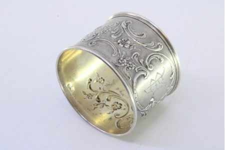 Argola de guardanapo em prata com relevos florais envolvendo cartela para monograma.